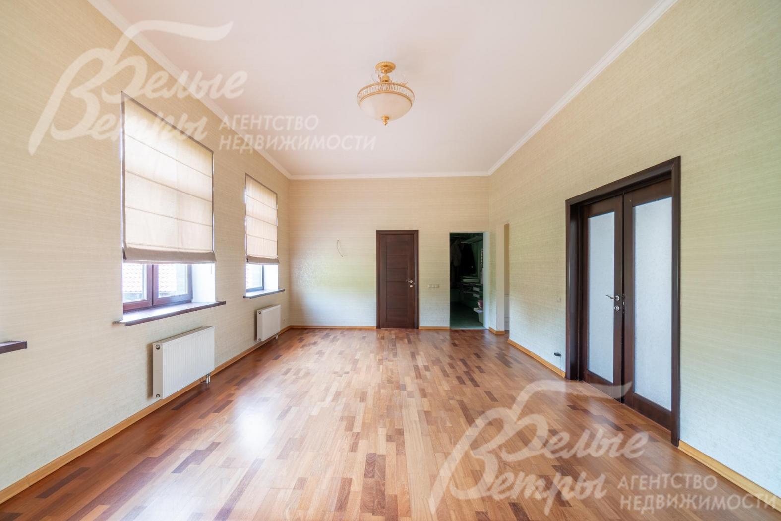 Мастер-спальня на втором этаже с большими окнами и представительной входной дверью из массива дерева