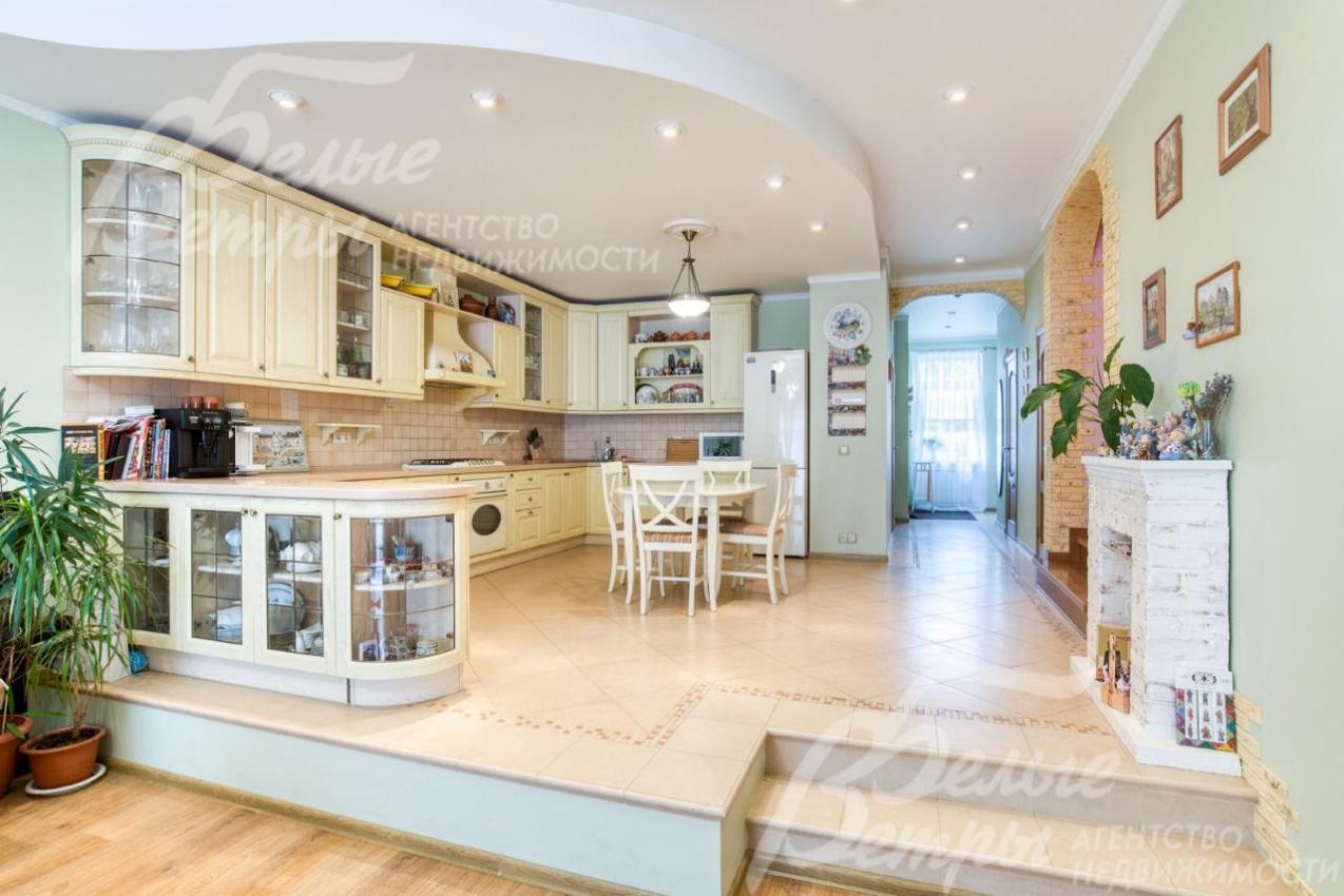 Кухня расположена на подиуме, дополнительное зонирование - угловым барным островом