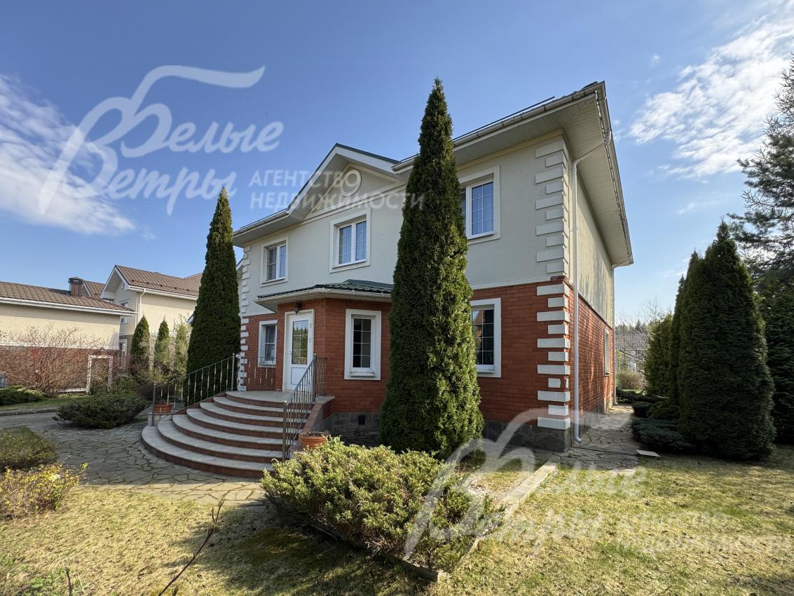 У парадного крыльца высажены две высокие взрослые туи