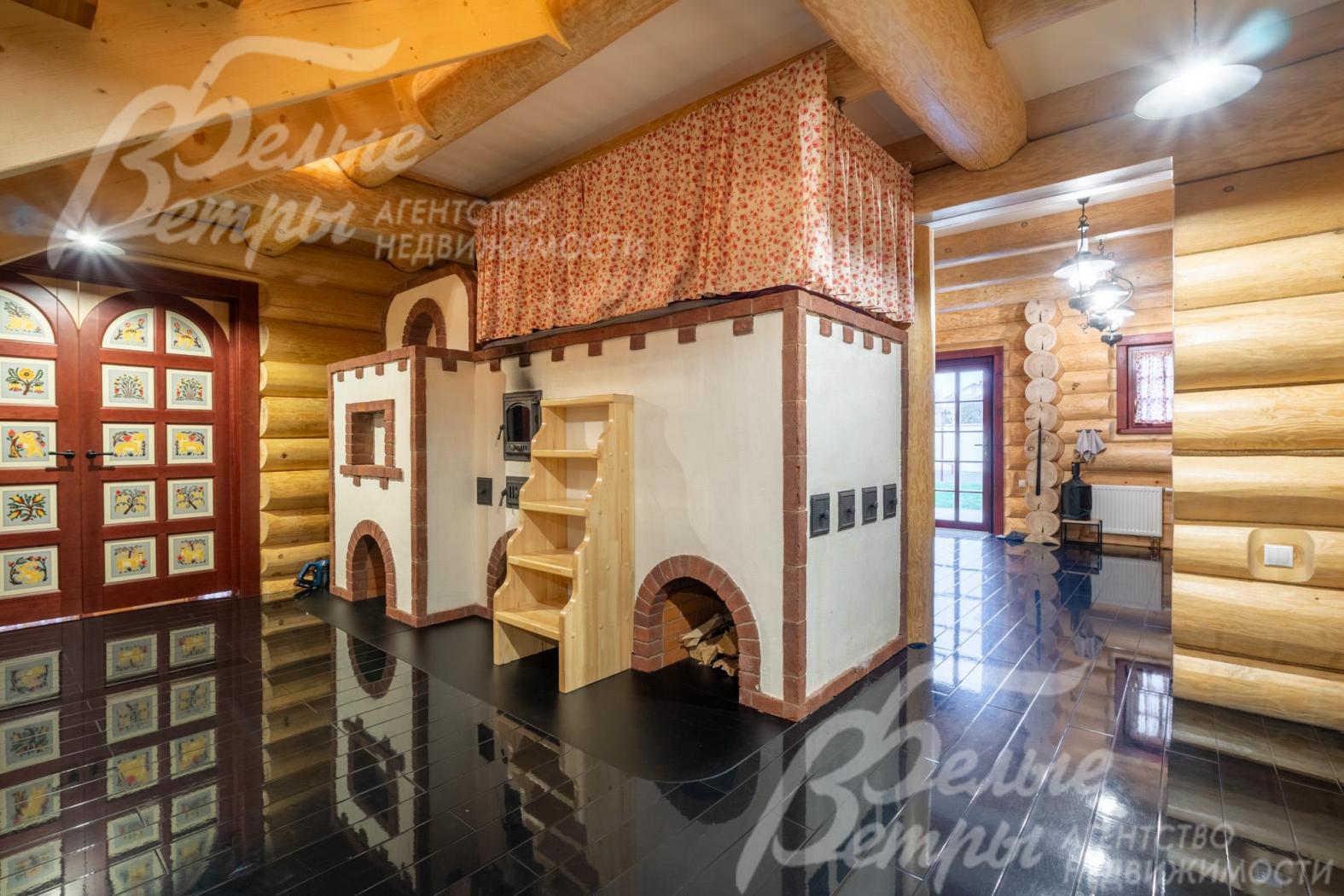 Центральный элемент в холле и кухне-столовой – кирпичная русская печь ручной работы: на печи - просторная лежанка размером с двуспальную кровать и специальная лестница для подъёма