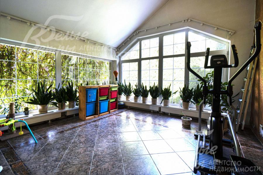 Зимний сад на первом этаже со спортивными тренажёрами