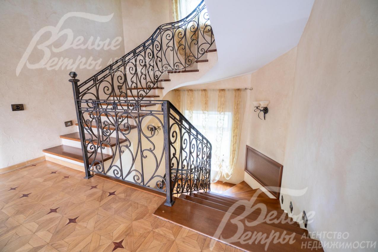 На второй этаж ведёт лестница с отделкой ступеней массивом ореха и кованым ограждением