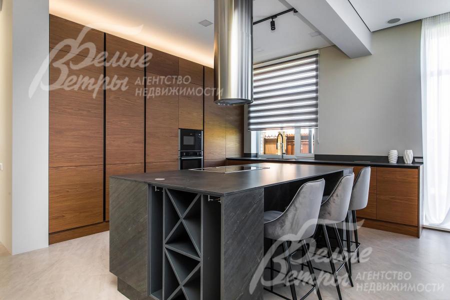 Кухонный гарнитур из шпона ореха, остров облицован шпоном из натурального камня, столешница – Compact HPL FunderMax (Австрия), встроенная техника Neff (Германия)