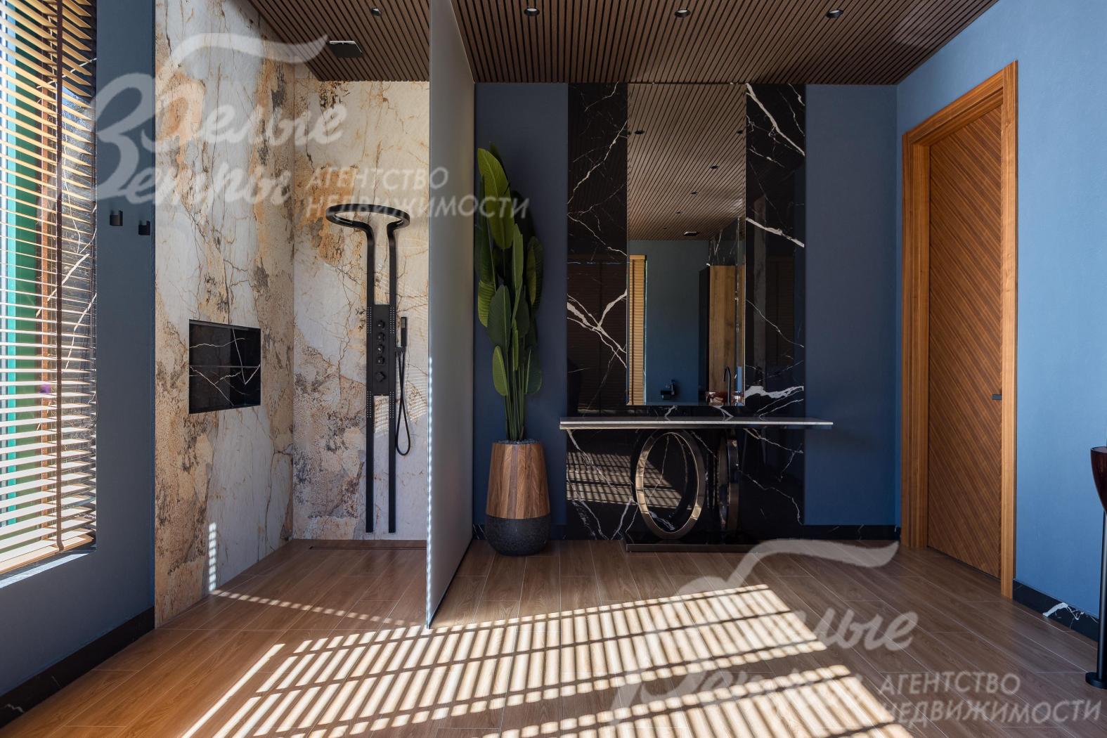 В санузле мастер-спальни также есть просторная душевая кабина, отделанная слэбами мрамора