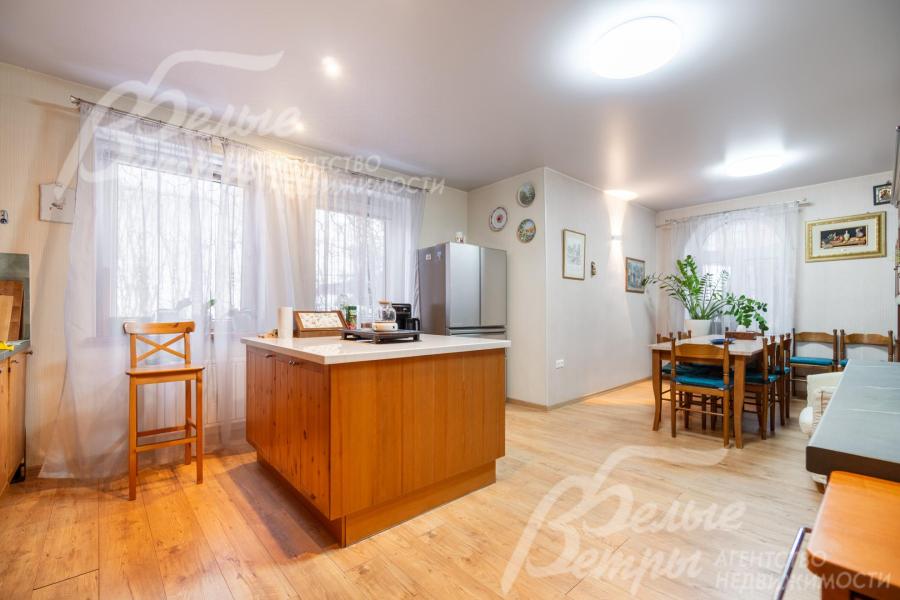 В кухне-столовой есть обеденная группа, рядом с островом находится холодильник side-by-side Mitsubishi