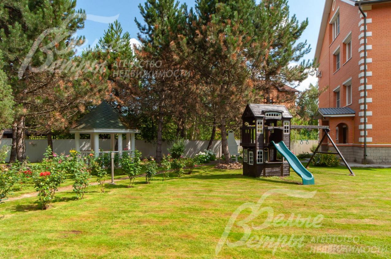 Детская игровая горка с качелями на участке.