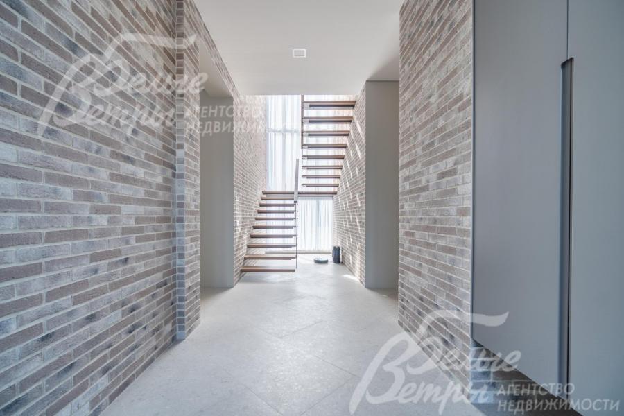 Холл дома: стены отделаны декоративной плиткой «под фасадный кирпич», они органично продолжают внешнюю отделку дома