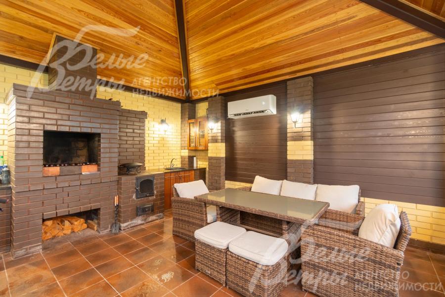 В беседке установлены мангал, печь, мебель из ротанга, подведена вода, обустроена кухня