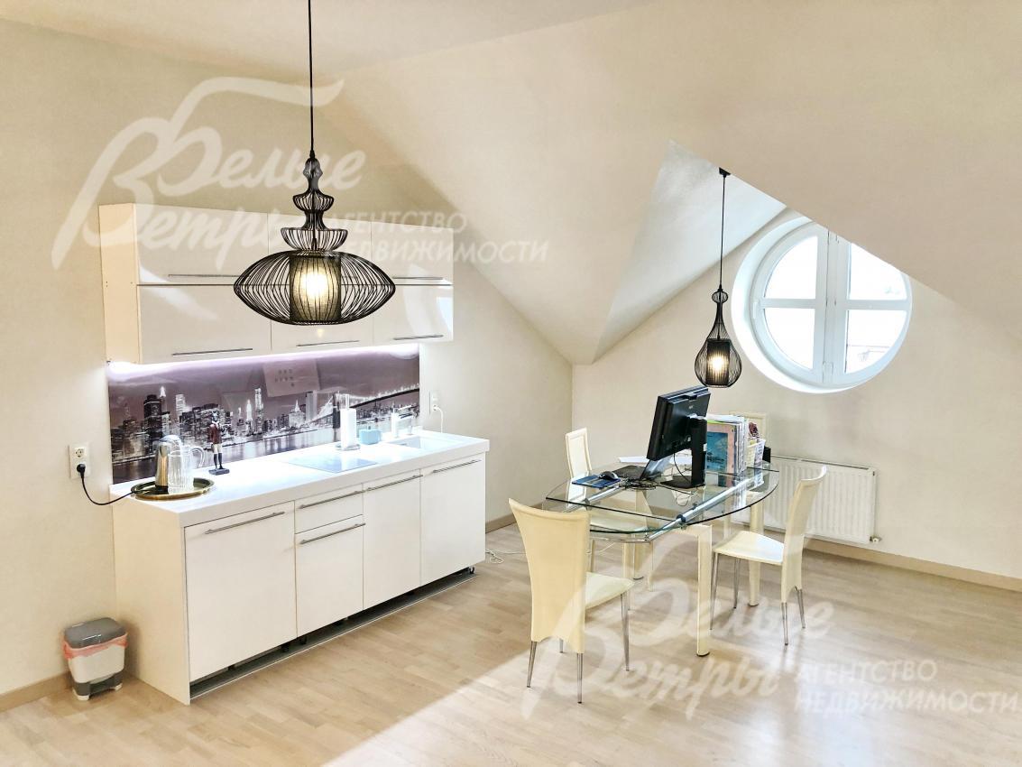 Гостиная на мансарде площадью 55 кв.м, оборудованная кухней