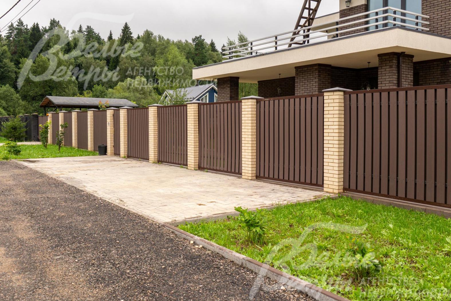 Участок огорожен забором на кирпичных столбах высотой 2 м 