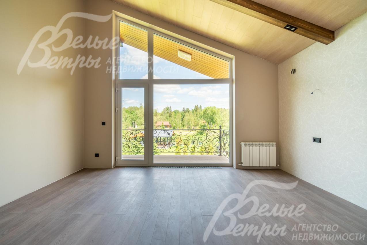 Спальня на втором этаже с большим окном в пол и выходом на балкон