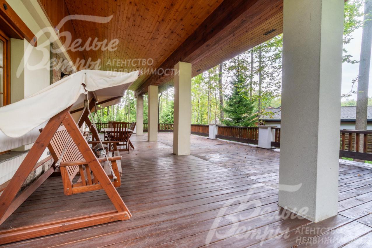 На просторной террасе установлены качели и садовая мебель, есть зона для гриля