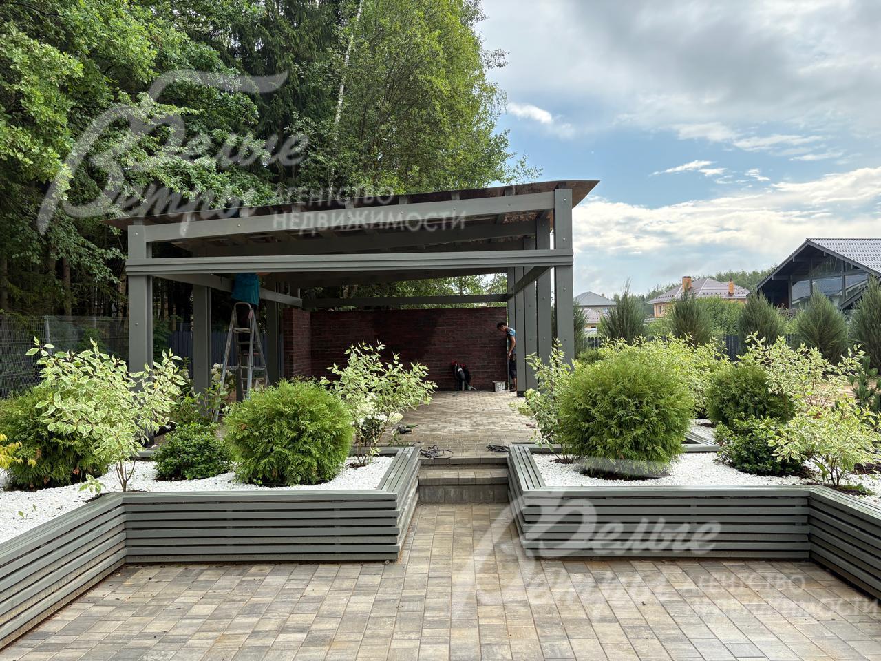 Беседка расположена на подиуме, к ней ведут ступени между клумбами