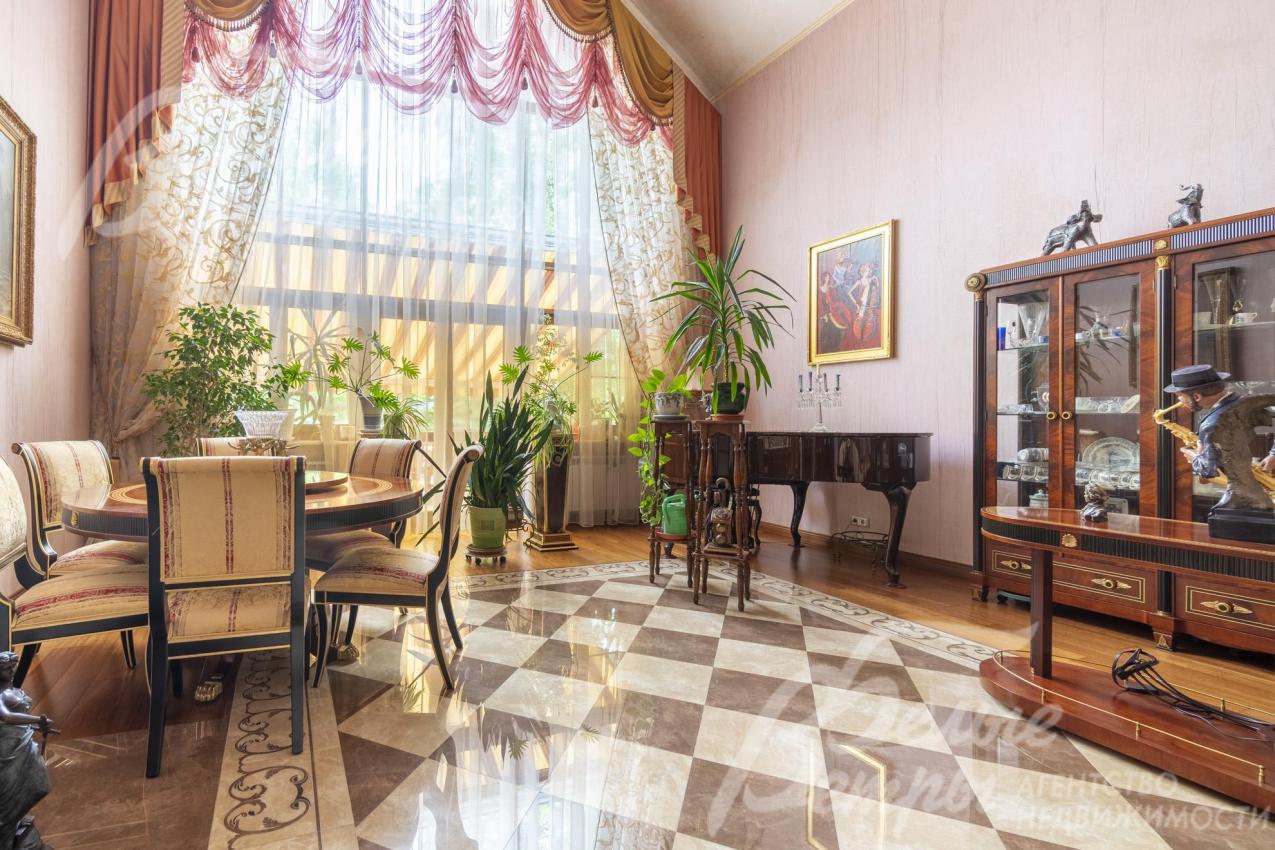 В гостиной стоит обеденная группа и рояль