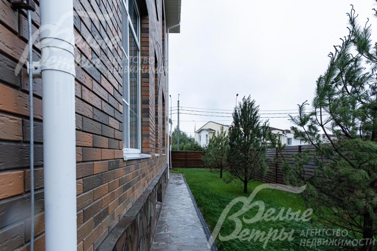 По периметру участка газон и хвойные деревья