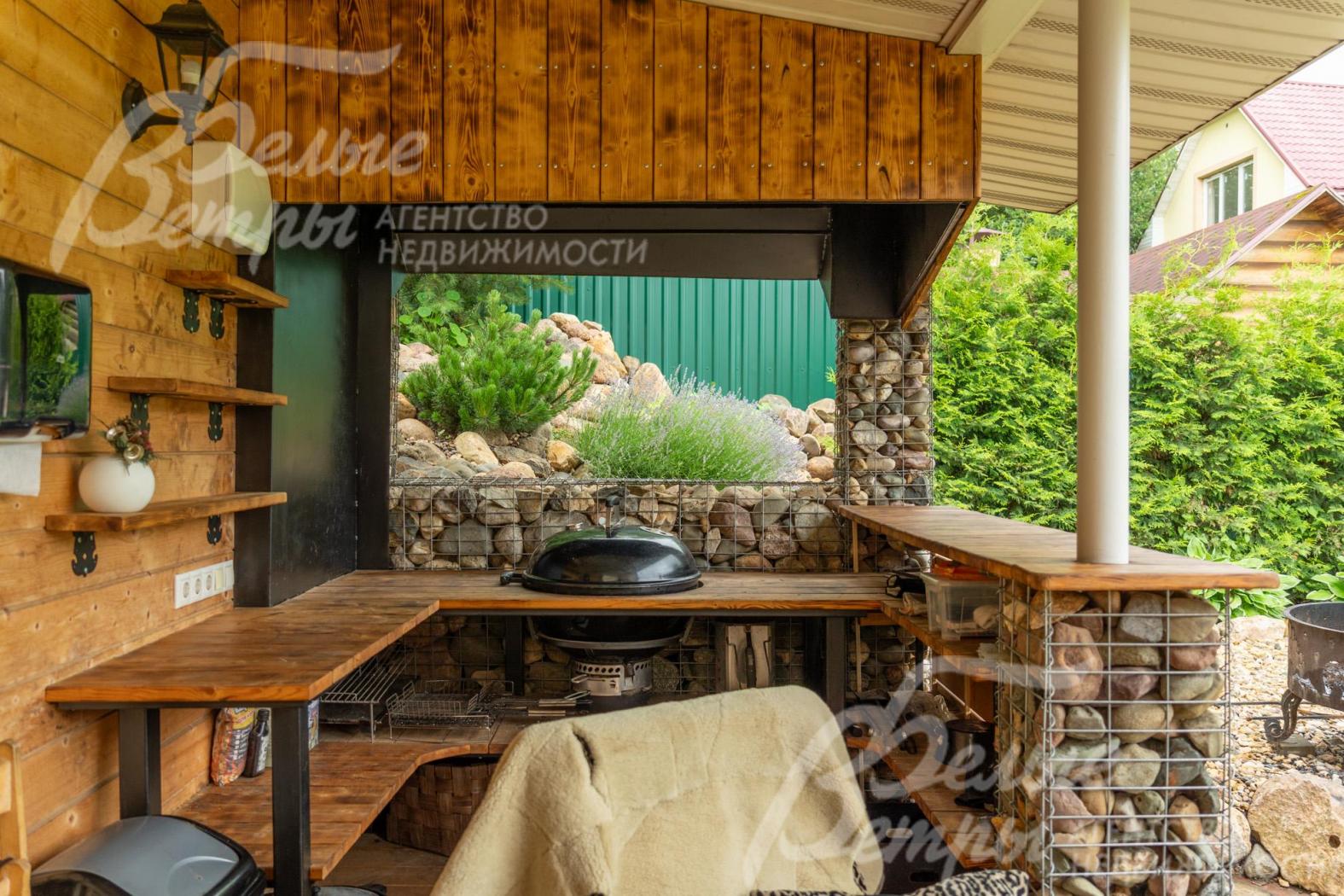 Беседка декорирована габионами, установлен гриль